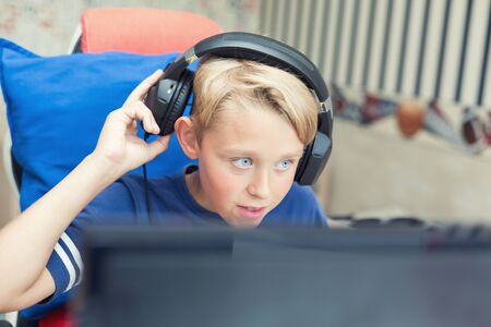 Teenage boy playing computer games on PCの写真素材