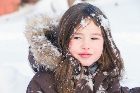 Beautiful little girl playing in snowの写真素材