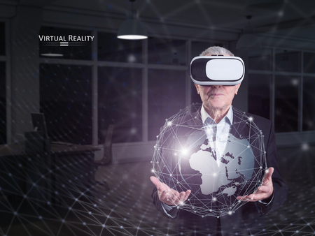 An old man using a virtual reality headsetの写真素材