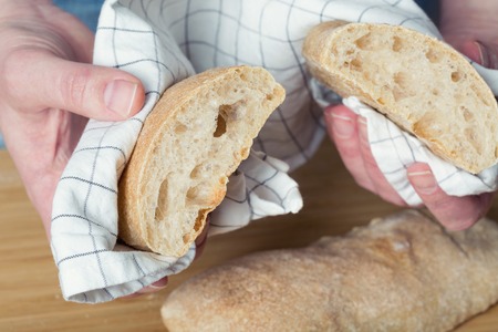 Female hands holding ciabatta breadの写真素材