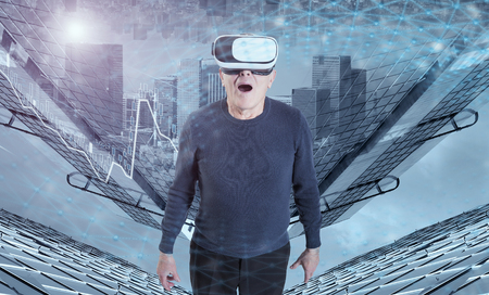 An old man in VR headset against a city buildings background.の写真素材