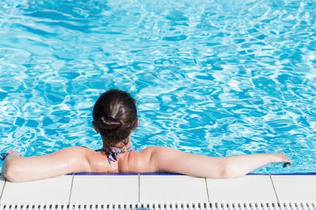 Beautiful woman relaxing in a swimming poolの写真素材