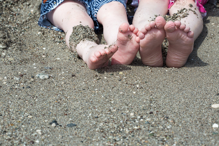 Child feet in the sand on a beachの写真素材