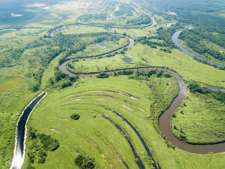 Aerial landscape of winding river in green fieldsの写真素材