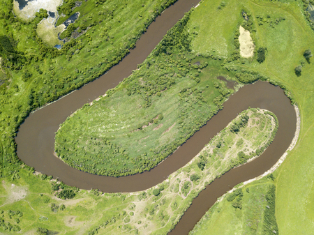 Aerial landscape of winding river in green fieldsの写真素材
