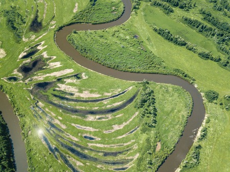 Aerial landscape of winding river in green fieldsの写真素材