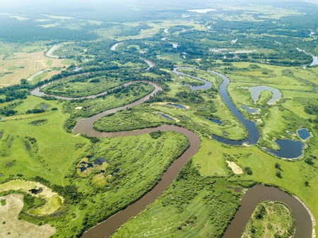 Aerial landscape of winding river in green fieldsの写真素材