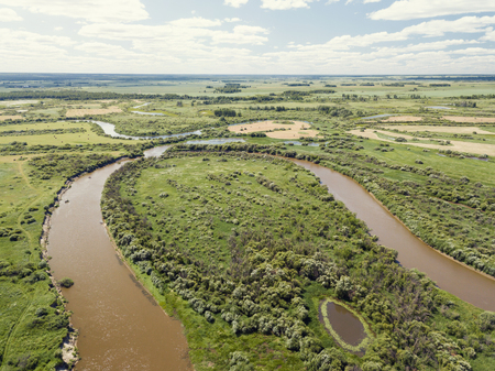 Aerial landscape of winding river in green fieldsの写真素材