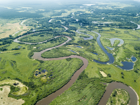 Aerial landscape of winding river in green fieldsの写真素材