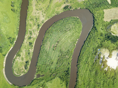 Aerial landscape of winding river in green fieldsの写真素材