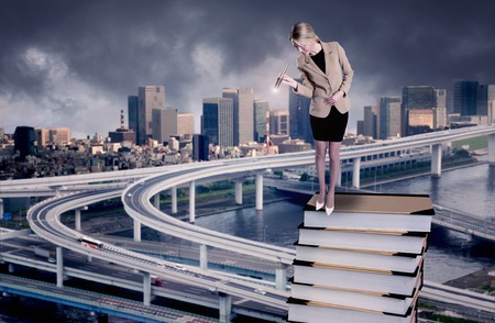A Businesswoman standing on a stack of books