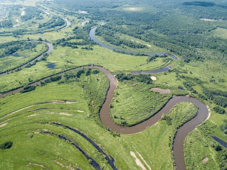 Aerial landscape of winding river in green fieldsの写真素材