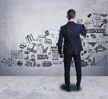 A businessman drawing a business sketch on the wallの写真素材