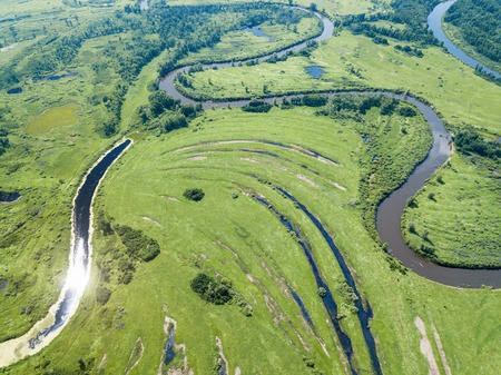 Aerial landscape of winding river in green fieldsの写真素材
