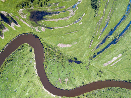 Aerial landscape of winding river in green fieldsの写真素材