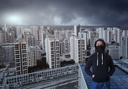 Suspicious man in hoody against urban backgroundの写真素材