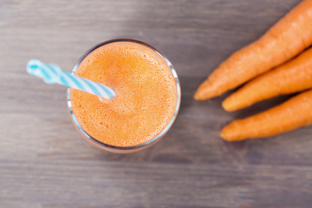 A glass of healthy carrot smoothie with carrotsの写真素材