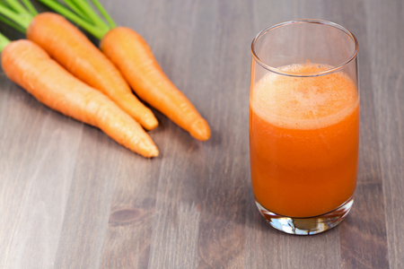 A glass of healthy carrot smoothie with carrotsの写真素材