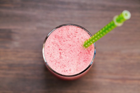 Watermelon smoothie in a glass with a green tubeの写真素材