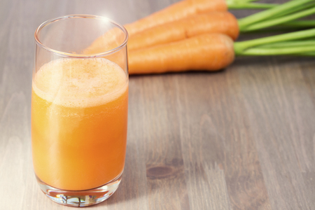 A glass of healthy carrot smoothie with carrotsの写真素材