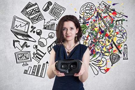 Young woman with VR headset standing against a wall with arts and science sketchの写真素材