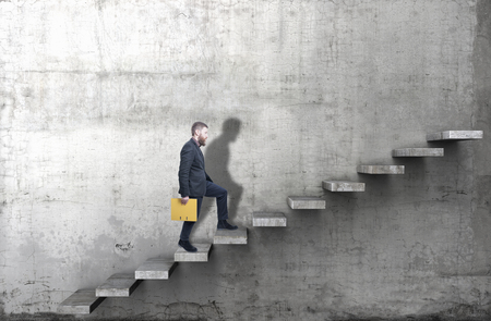 Side view of a man climbing up the steps in a blank concrete wall. 3d render