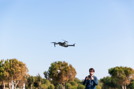 A man piloting a drone in the park in spring-summer timeの写真素材