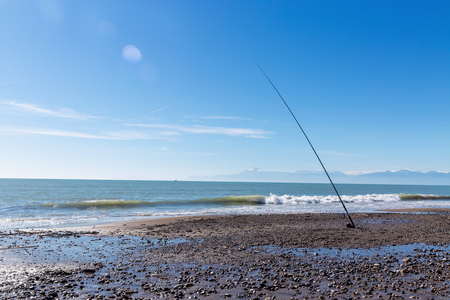 Fishing rods on the beach on sunny dayの写真素材