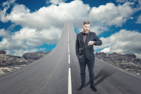 Businessman standing on road that goes up to the skyの写真素材