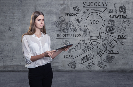 Beautiful business woman against a concrete wall with sketch drawn on itの写真素材