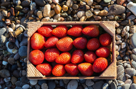 A box full of ripe strawberries on stone background. Organic food conceptの写真素材