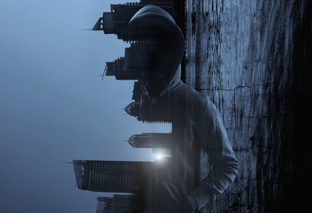 Suspicious man in hoody against city backgroundの写真素材
