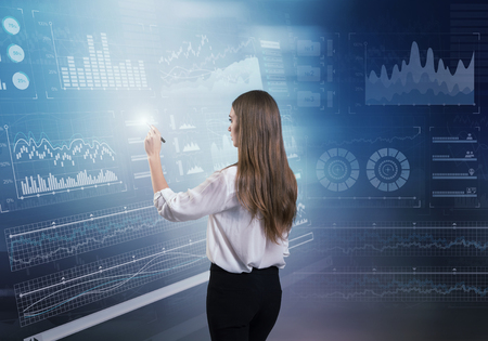 Back view of businesswoman working with virtual panelの写真素材
