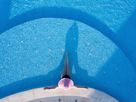 Young woman sunbathing in a swimming poolの写真素材