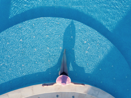 Young woman sunbathing in a swimming poolの写真素材