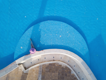 Young woman sunbathing in a swimming poolの写真素材