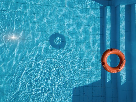 Orange lifebuoy in a swimming pool in summerの写真素材