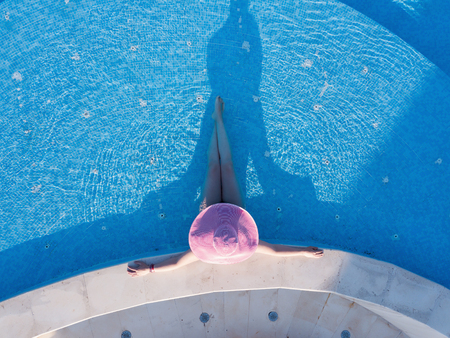 Young woman sunbathing in a swimming poolの写真素材