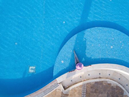 Young woman sunbathing in a swimming poolの写真素材