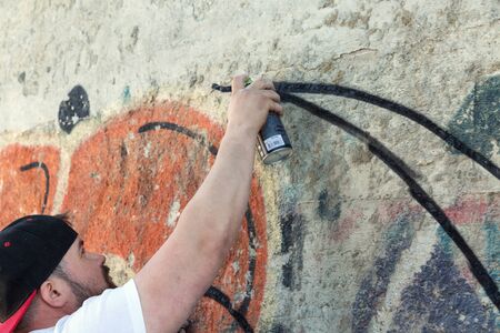 Graffiti artist painting with aerosol spray bottleの写真素材