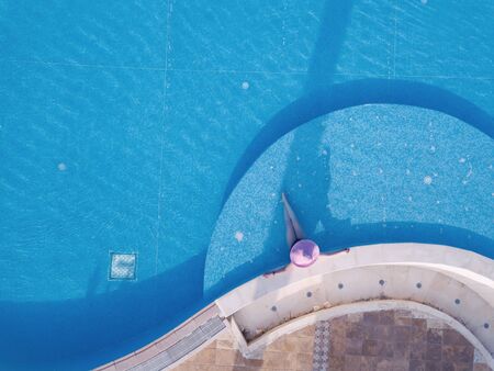 Young woman sunbathing in a swimming poolの写真素材