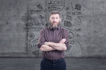Handsome businessman against a concrete wall with sketch drawn on itの写真素材