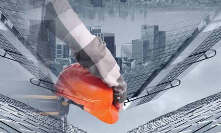A female construction worker with safety helmet against city backgroundの写真素材