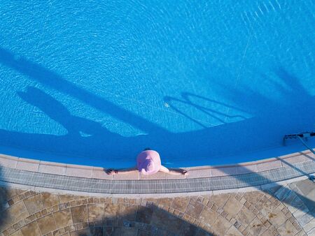 Young woman sunbathing in a swimming poolの写真素材