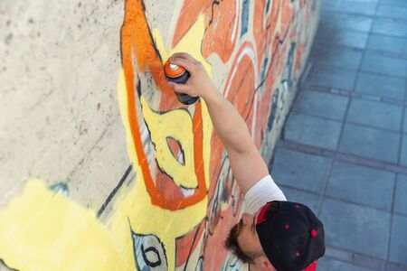 Graffiti artist painting with aerosol spray bottleの写真素材