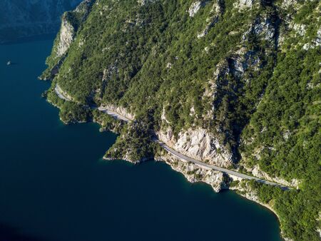 Aerial photo of a long winding road on Piva Lake in Montenegroの写真素材