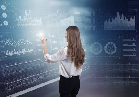Back view of businesswoman working with virtual panelの写真素材