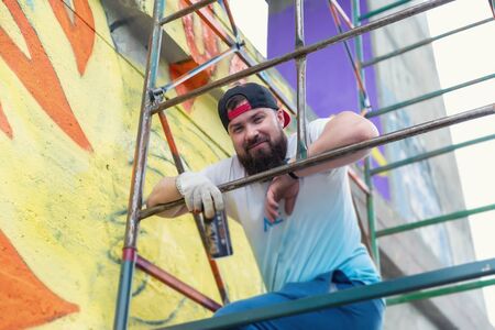 Graffiti artist painting with aerosol spray bottleの写真素材
