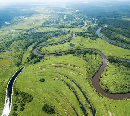 Aerial landscape of winding river in green fieldsの写真素材