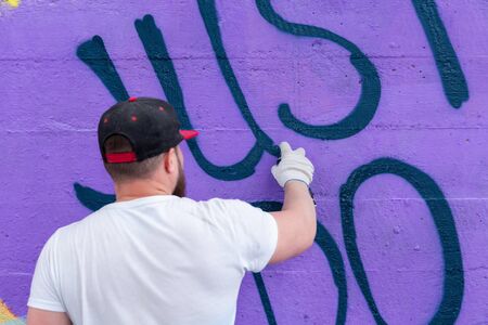 Graffiti artist painting with aerosol spray bottleの写真素材